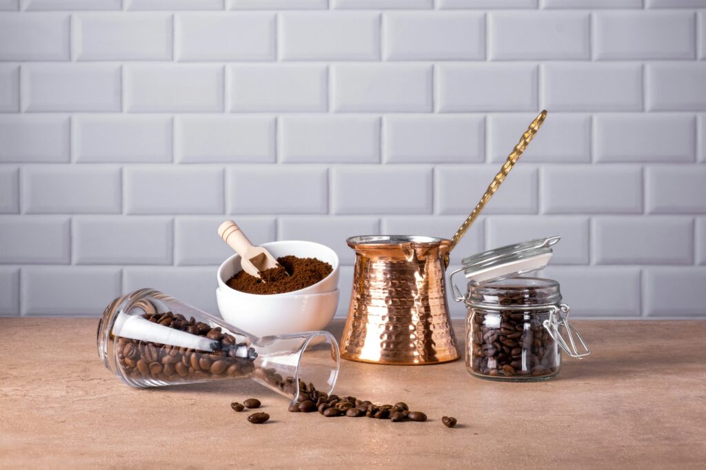 Coffee beans and ground coffee in glass and porcelain containers.