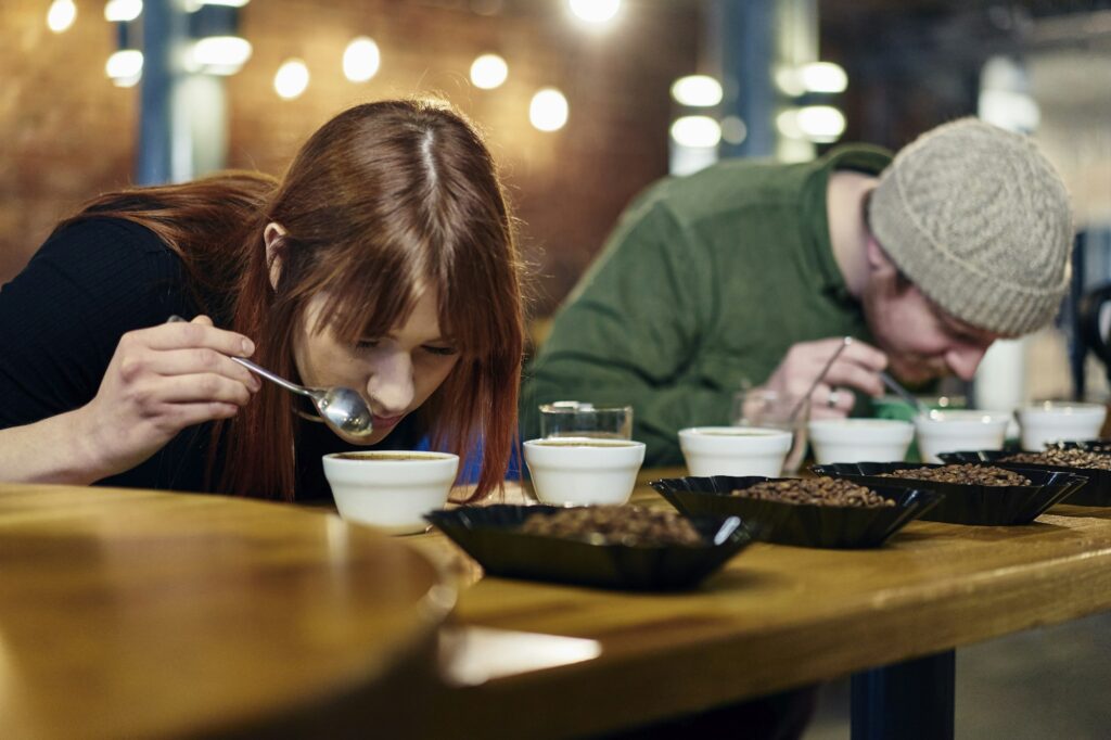 Coffee shop team smelling bowls of coffee and coffee beans at tasting