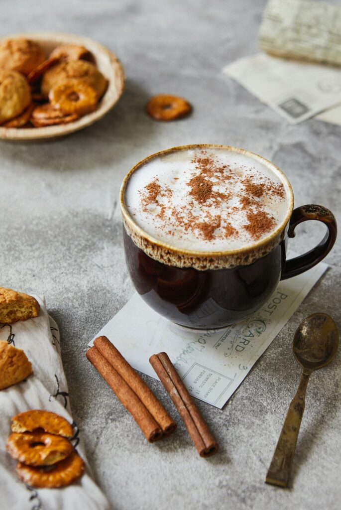 Cup with cocoa or coffee with milk cinnamon and cookies on a light gray background