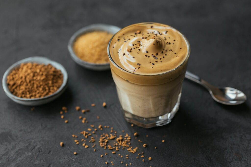 Glass of Iced Dalgona Coffee, trendy fluffy creamy whipped coffee and milk